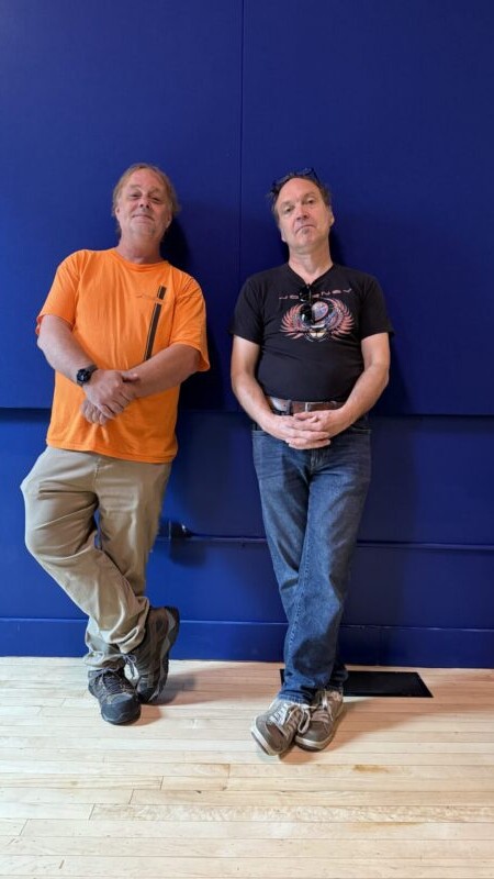 Two people against a blue wall